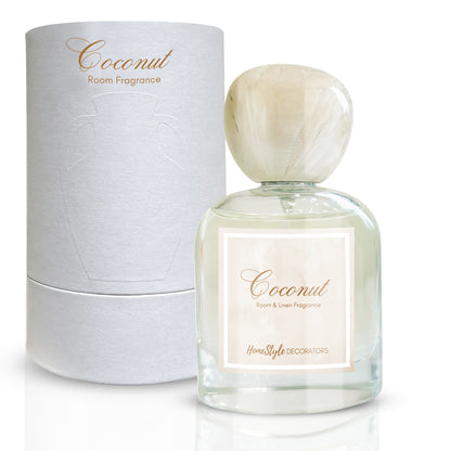 A bottle of 'Coconut' room and linen fragrance by Homestyle Decorators, accompanied by its white cylindrical packaging box, with a label and a marble top cap.